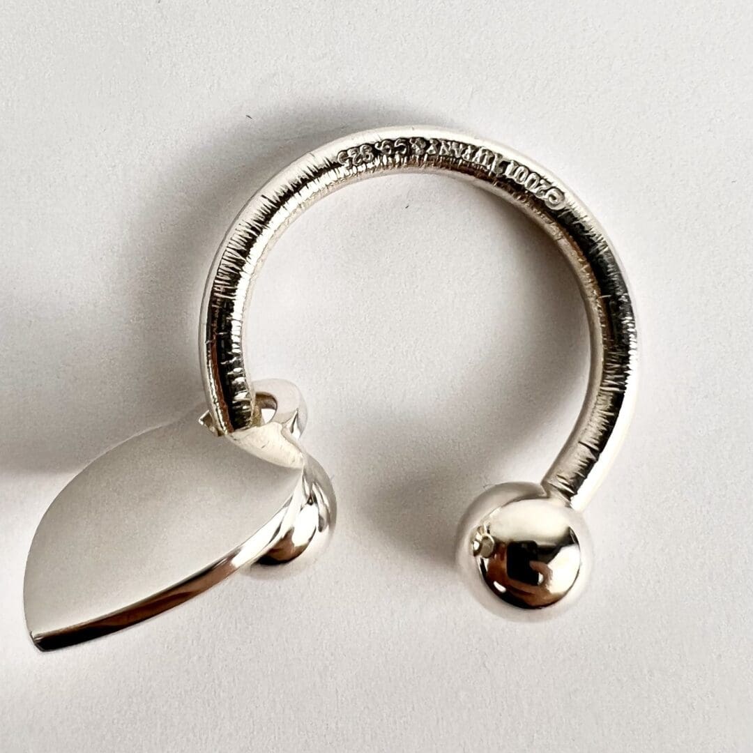 Silver ring with leaf and ball design.