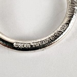 Silver ring with engraved text detail.