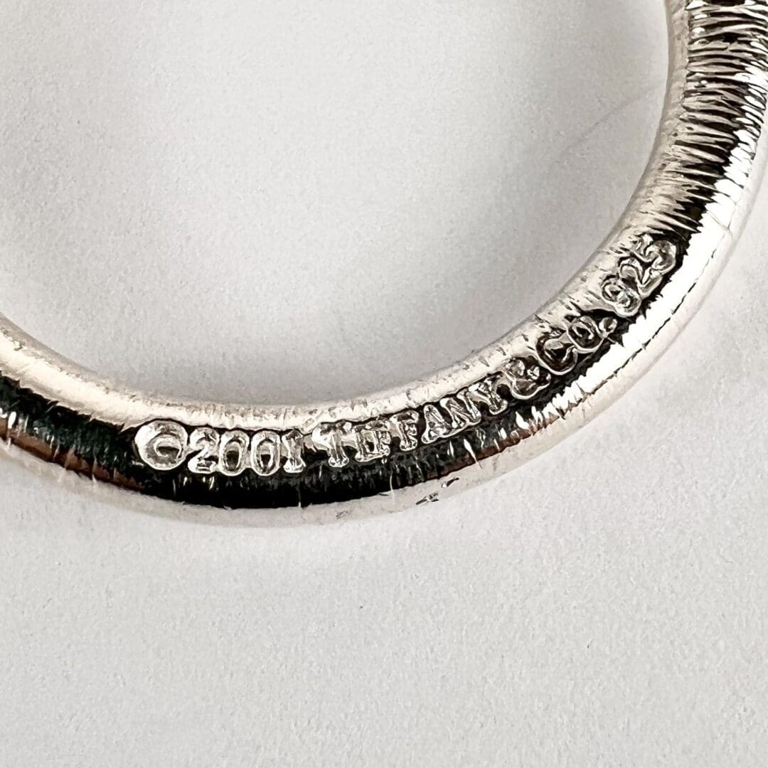 Silver ring with engraved text detail.