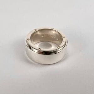 Silver ring with engraved text detail.