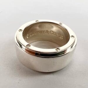 Silver ring with engraved brand logo.