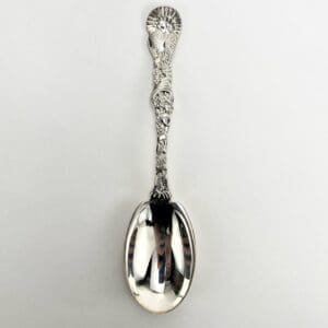Ornate silver spoon on white background.