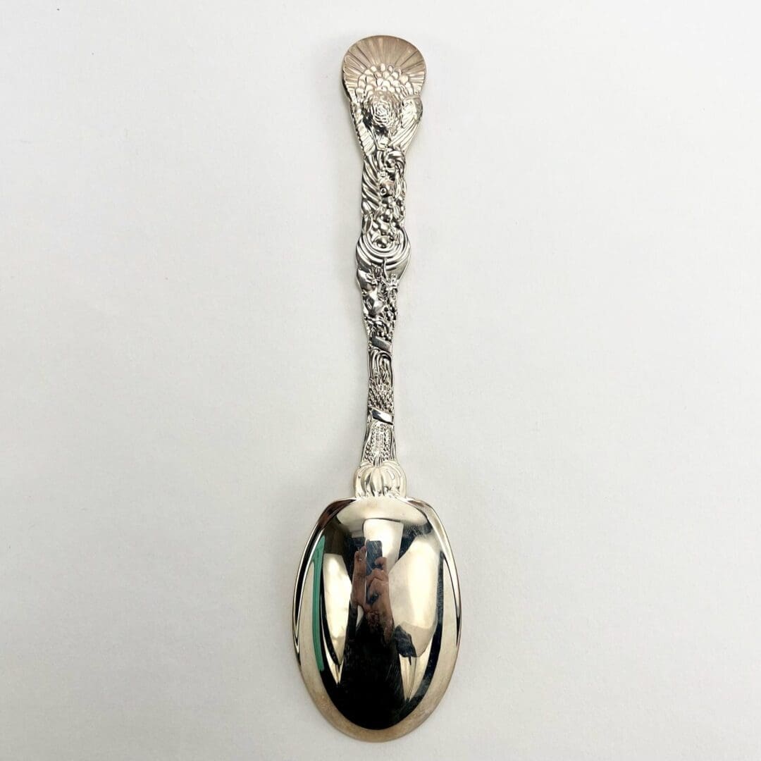Ornate silver spoon with intricate handle design.