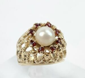 Gold ring with pearl and red stones.