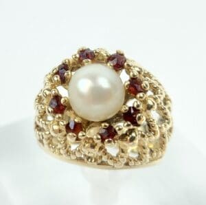 Gold ring with pearl and red gems.