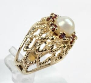 Gold ring with pearl and red stones.