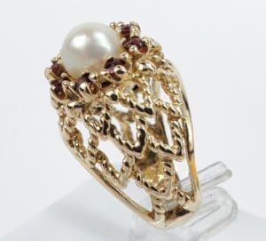 Gold ring with pearl and red stones.