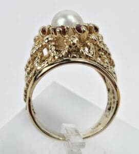 Gold ring with pearl and ornate design.