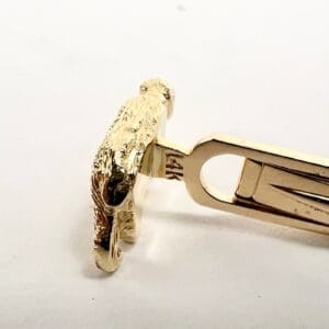 Gold tie clip shaped like a lion.