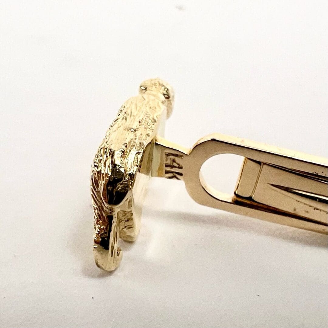 Gold tie clip shaped like a lion.