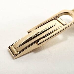 Gold tie clip on white background.