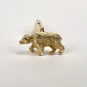 Gold bear-shaped cufflink on white background.