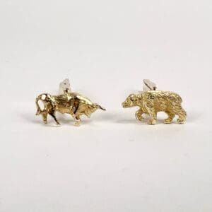 Bull and bear gold cufflinks on display.