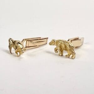 Gold animal-themed cufflinks on display.