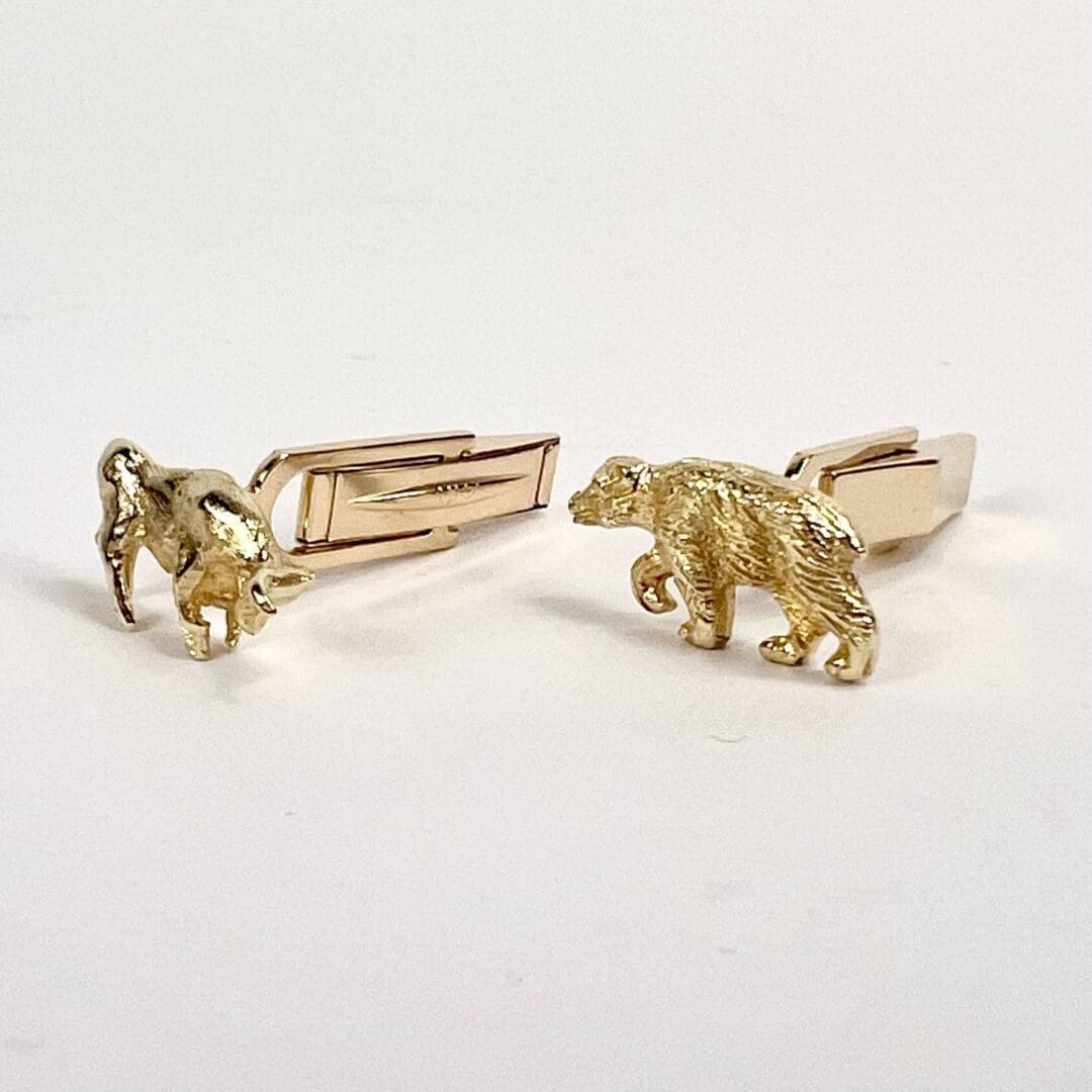 Gold animal-themed cufflinks on display.