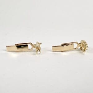 Gold bull and bear cufflinks on display.