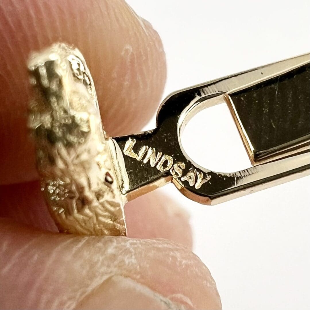 Gold ring with "Lindsay" engraving, close-up.