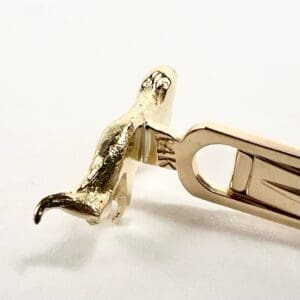 Golden animal-shaped tie clip on display.