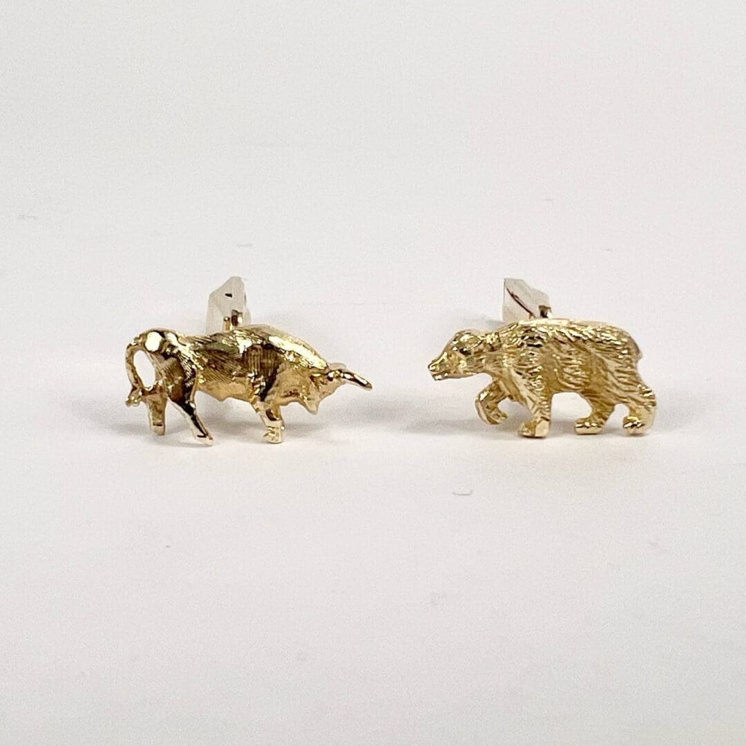 Bull and bear gold cufflinks on display.