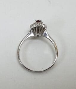 Silver ring with red gemstone on top.