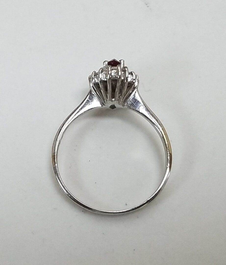 Silver ring with red gemstone on top.