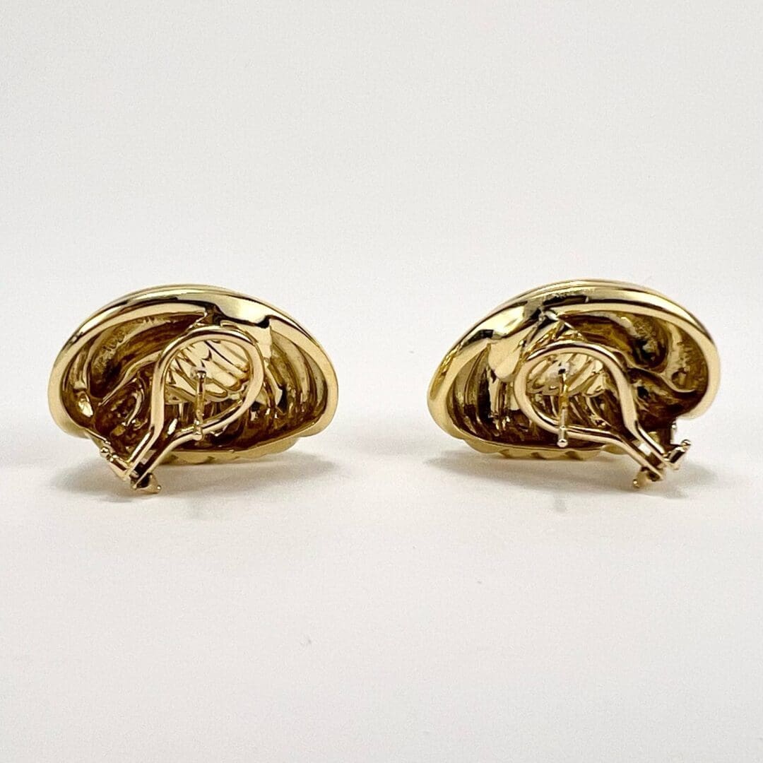 Gold seashell-shaped earrings on white background.