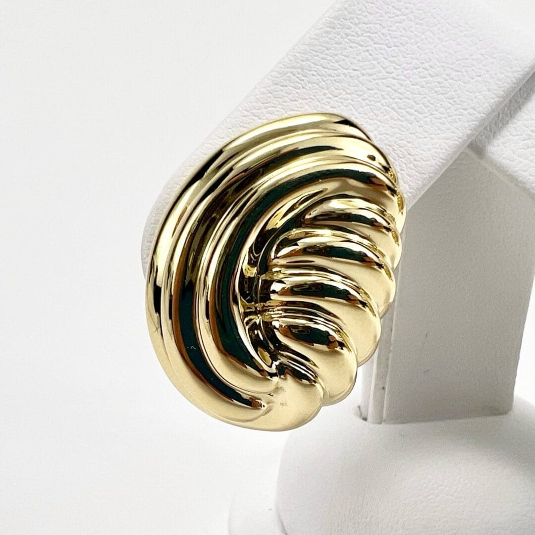 Gold statement ring on display stand.