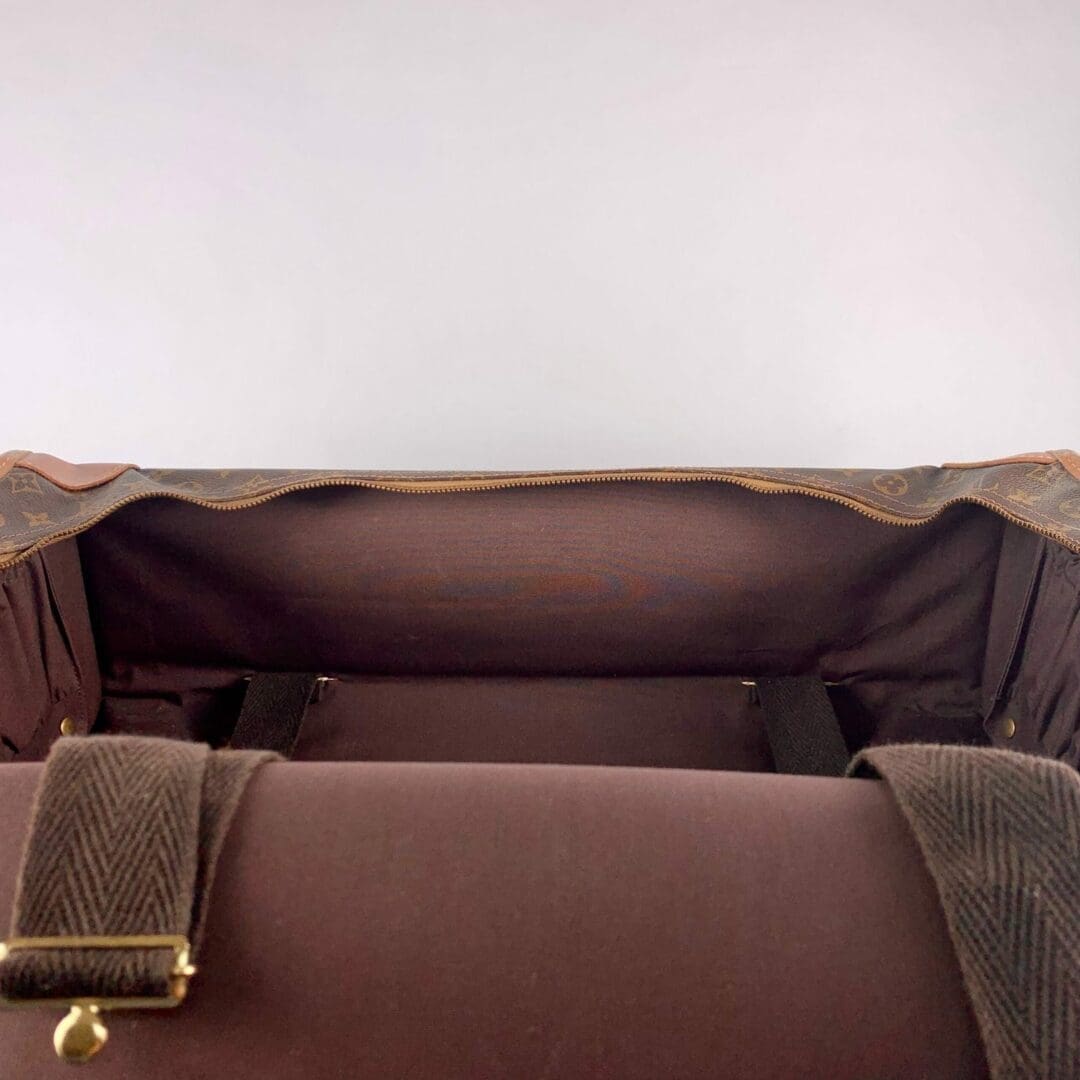 Open brown leather bag, empty interior view.