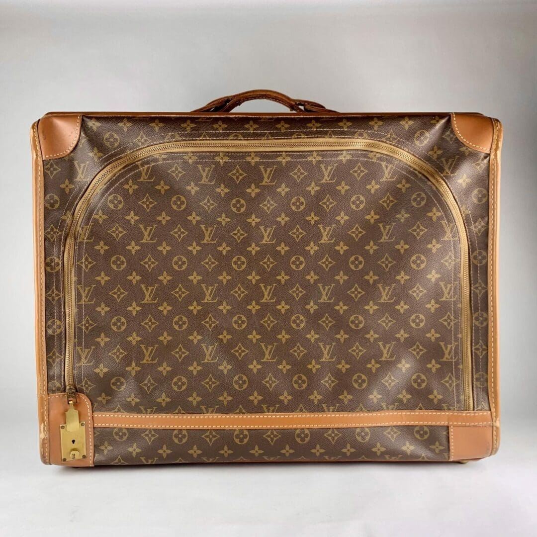 Brown designer suitcase with monogram pattern.