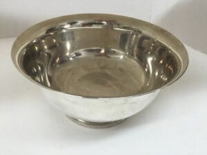 Silver metal bowl on white surface.
