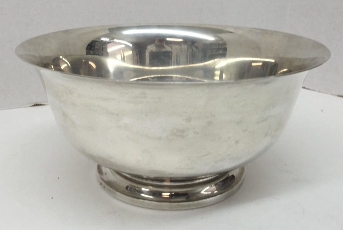 Silver metal bowl on a white surface.