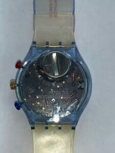 Transparent wristwatch showing internal battery components.