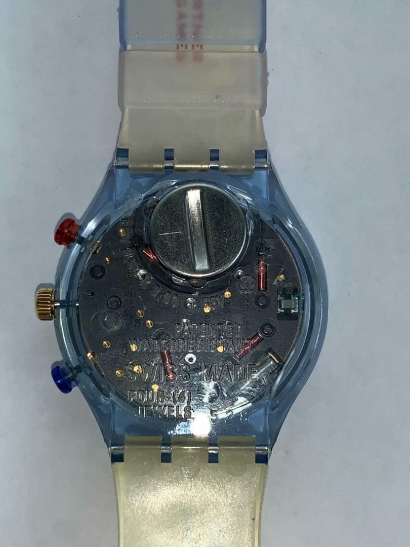 Transparent wristwatch showing internal battery components.