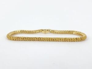Gold chain bracelet on white background.