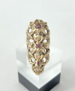 Gold ring with ornate face design.