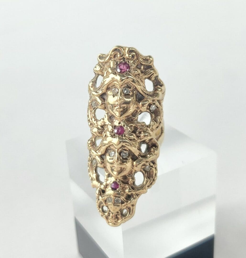 Ornate gold ring with red gemstones.