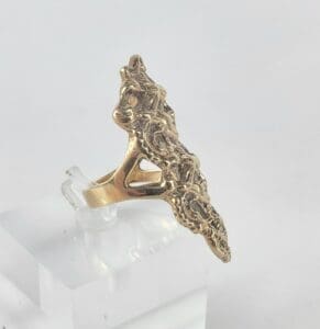 Gold ring with intricate sculptural design.