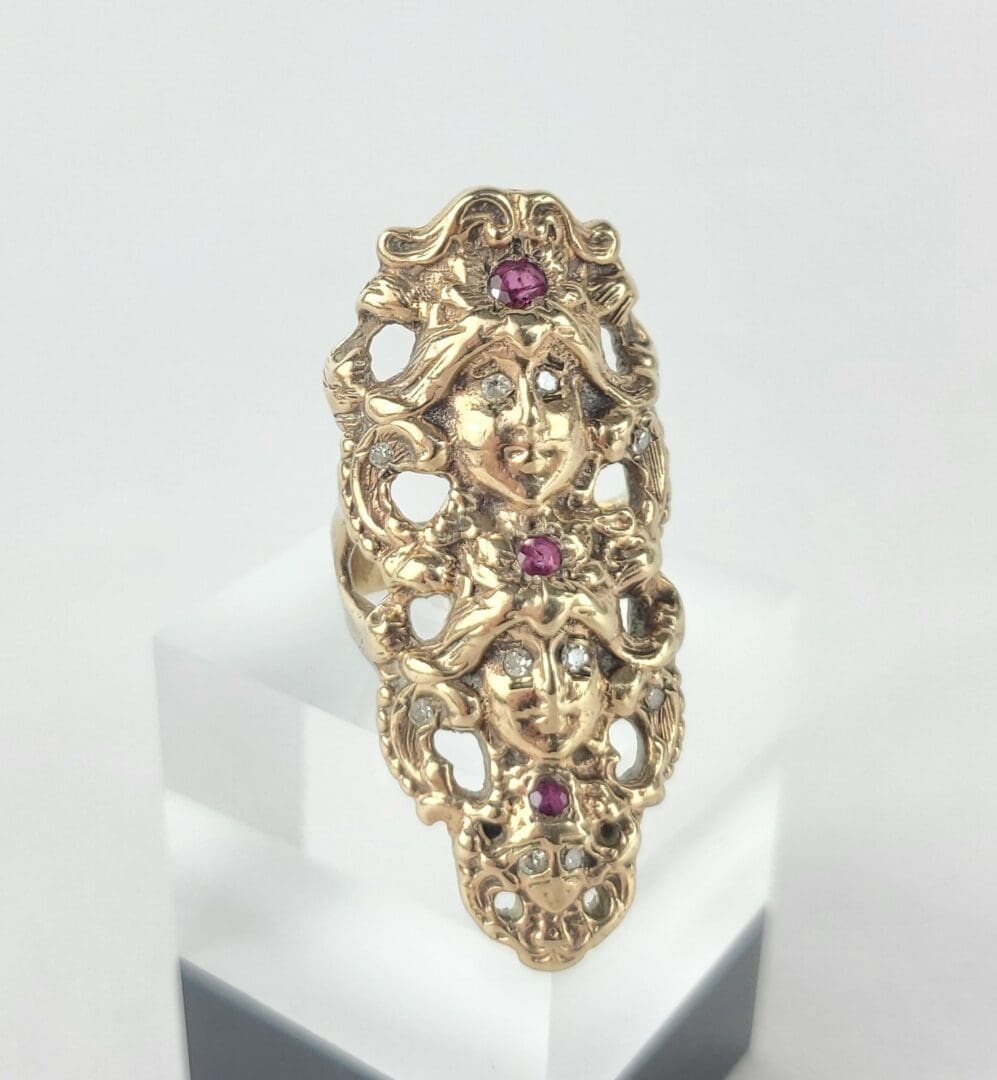 Ornate gold ring with red gemstones.