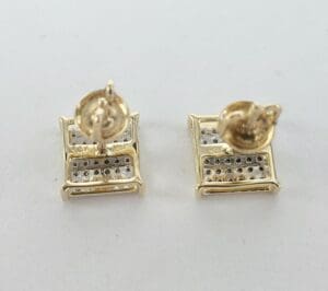 Gold square earrings on white background.