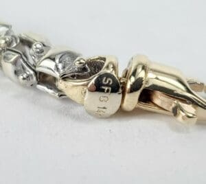 Gold and silver bracelet with clasp detail.