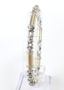 Silver and gold bangle on clear stand.