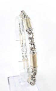 Silver and gold bracelet on display stand.