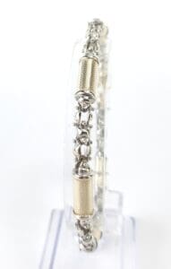 Silver and gold bracelet on clear stand.