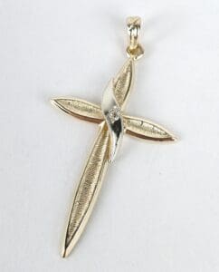 Gold cross pendant with textured design.