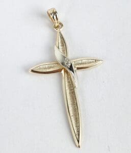 Gold cross pendant with silver accent.