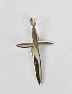 Gold cross pendant on white background.
