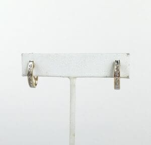 Gold hoop earrings with small diamonds.