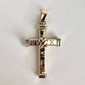 Gold cross pendant with intricate design.