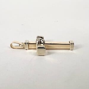 Gold and silver cross pendant on white.