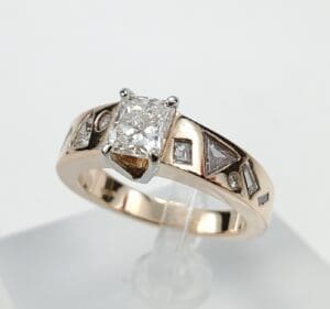 Gold ring with diamond and geometric designs.